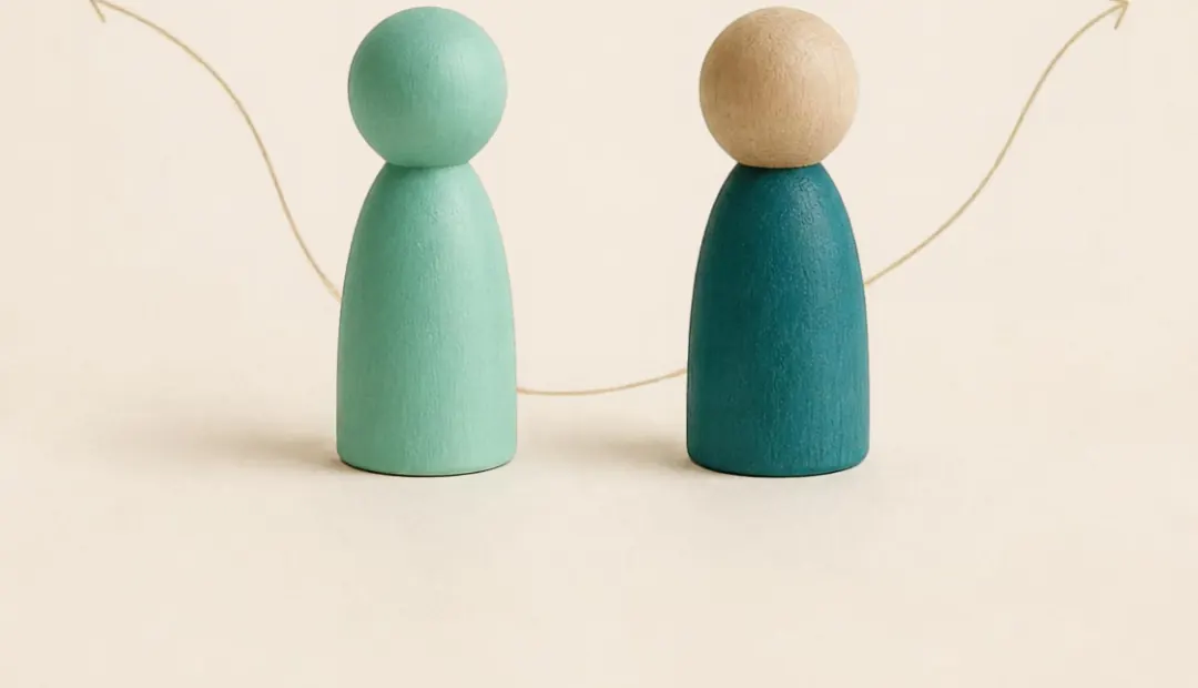 Dos figuras de madera frente a frente, como dos personas con apego ansioso y evitativo